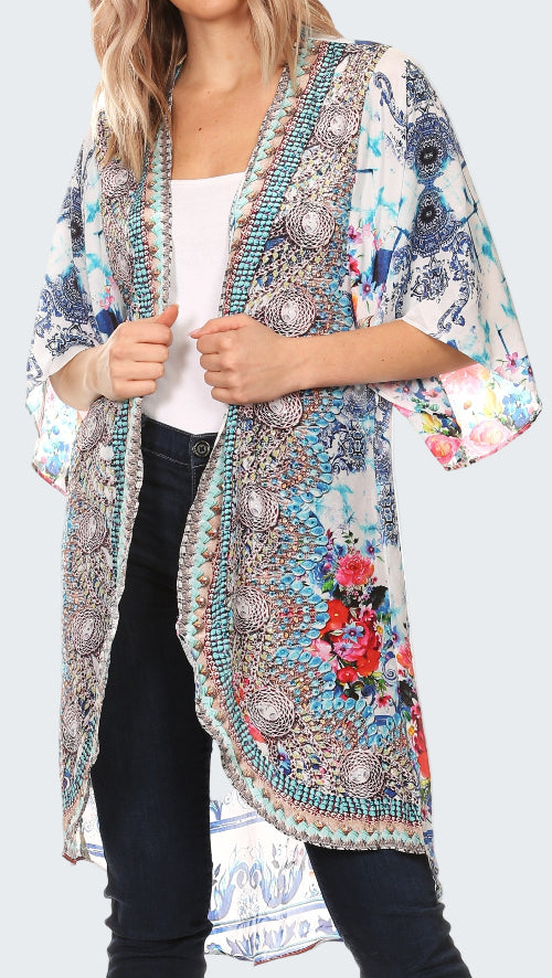 Woman wearing a colorful kimono-style jacket with floral and abstract patterns on a white background