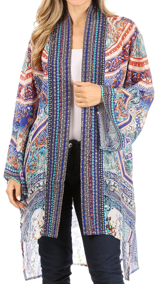 Woman wearing a colorful patterned cardigan over a white top and black pants.