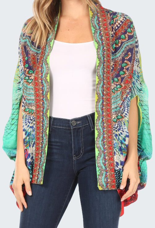 Woman wearing a colorful patterned kimono over a white top and dark jeans.