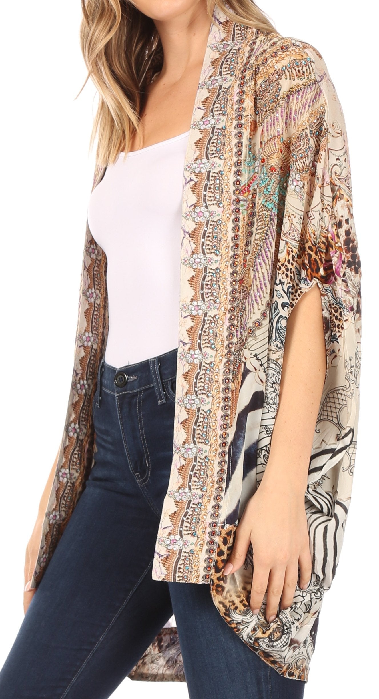 Woman wearing a patterned kimono over a white top and jeans on a white background