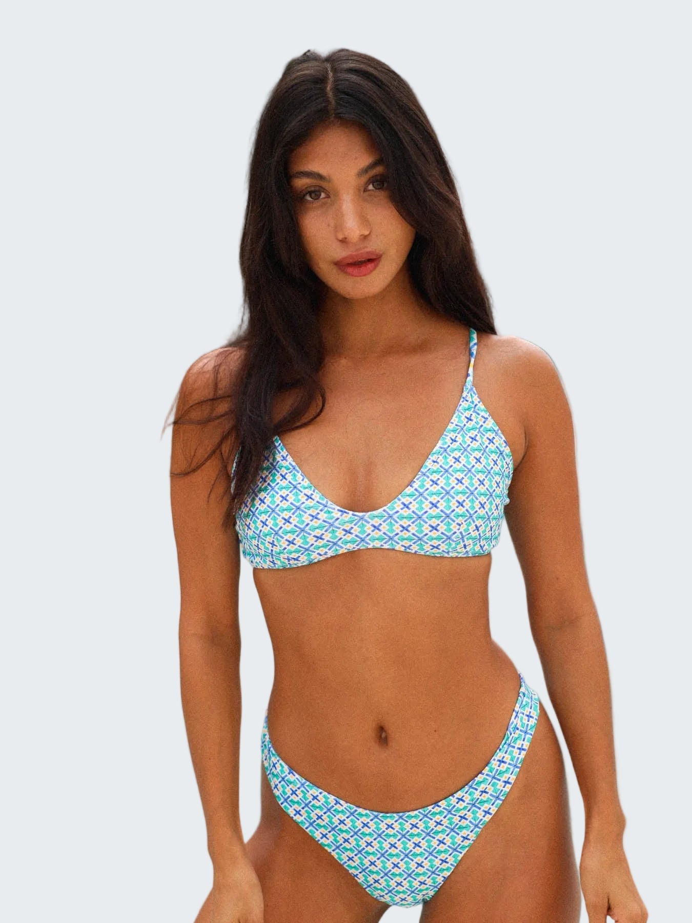 Woman wearing a blue patterned bikini by a pool