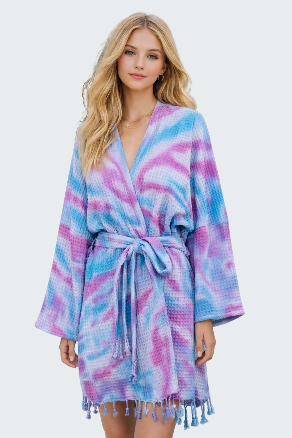 Woman wearing a colorful tie-dye robe by a poolside.