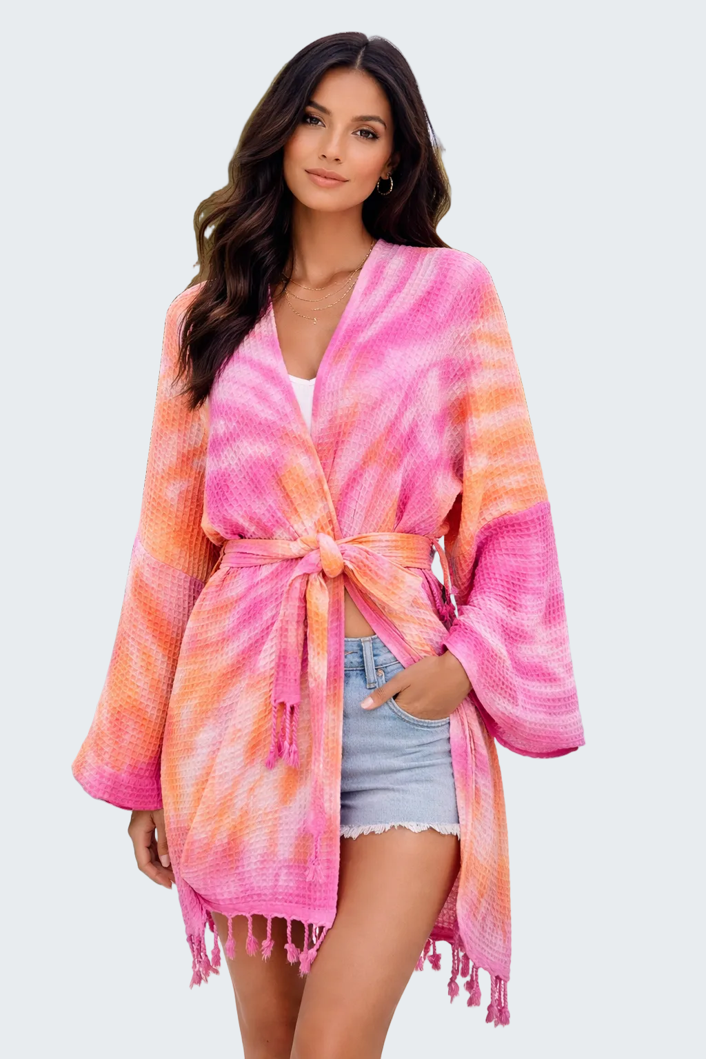 Woman wearing a pink and orange tie-dye kimono by a poolside.