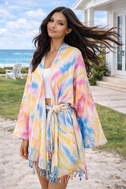 Woman wearing a colorful kimono-style robe by the beach