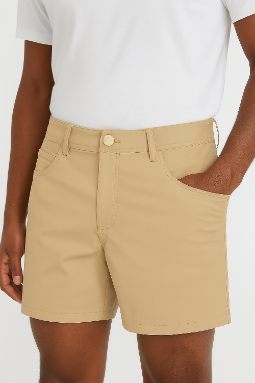 Person wearing beige shorts and a white shirt on a plain background