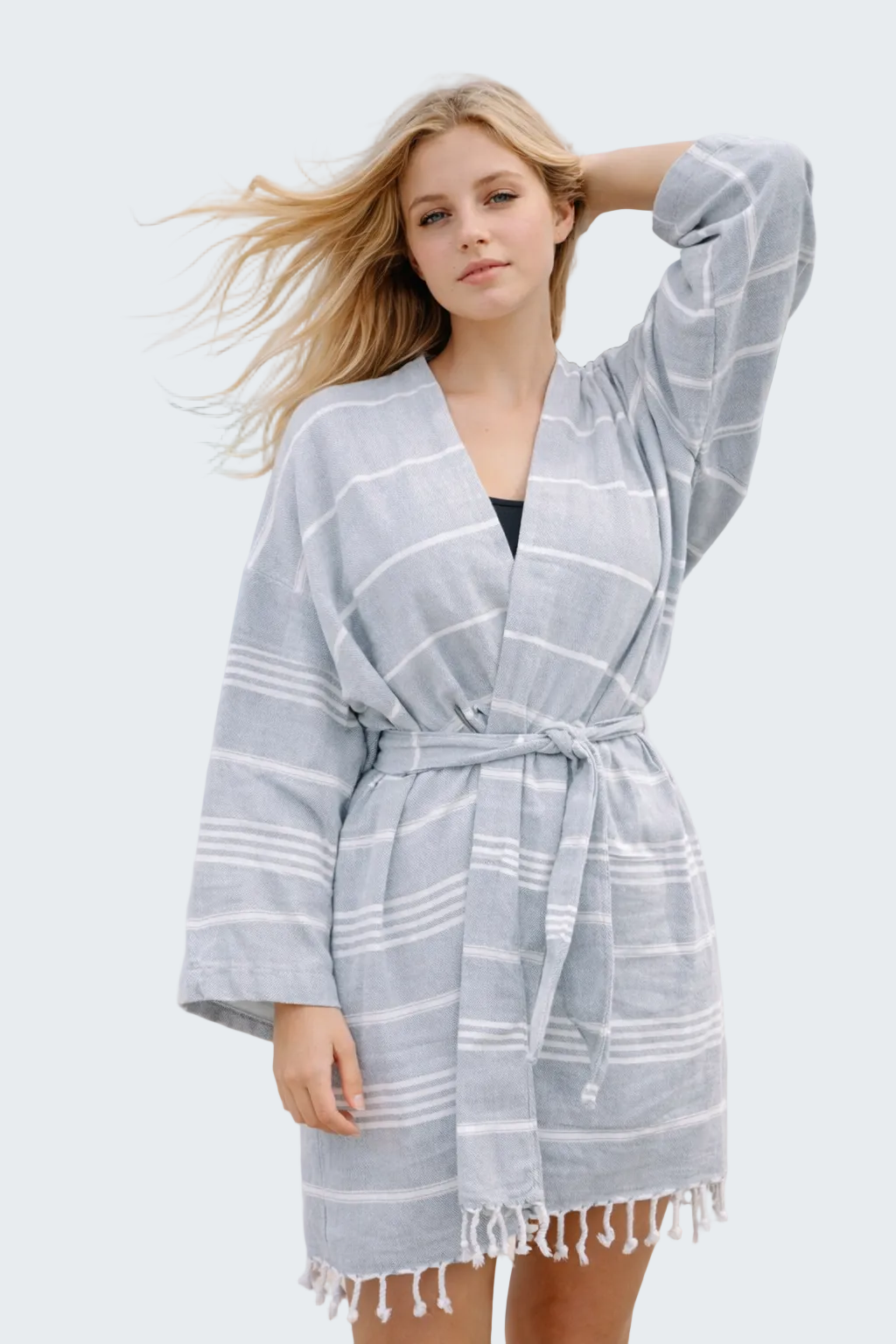 Woman wearing a gray and white checkered robe on a beach