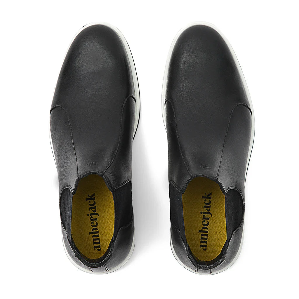Black slip-on shoes with 'amberjack' branding on a white background