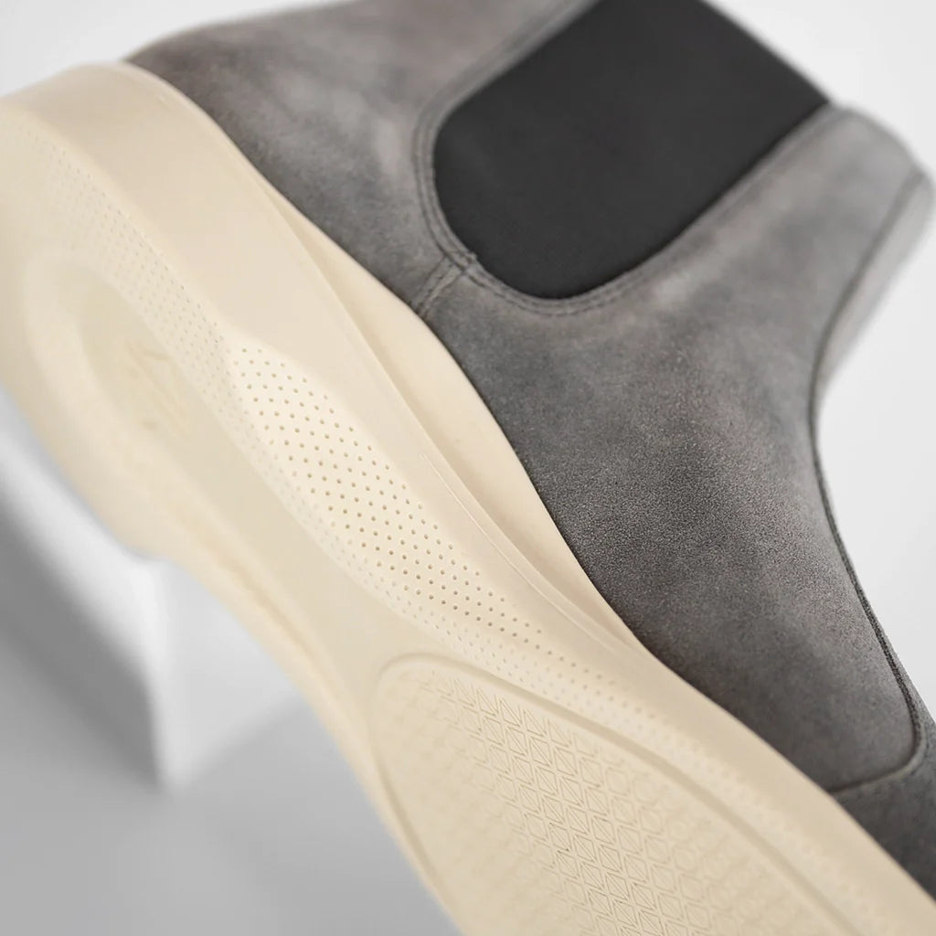 Close-up of a gray shoe with beige sole on a light gray background