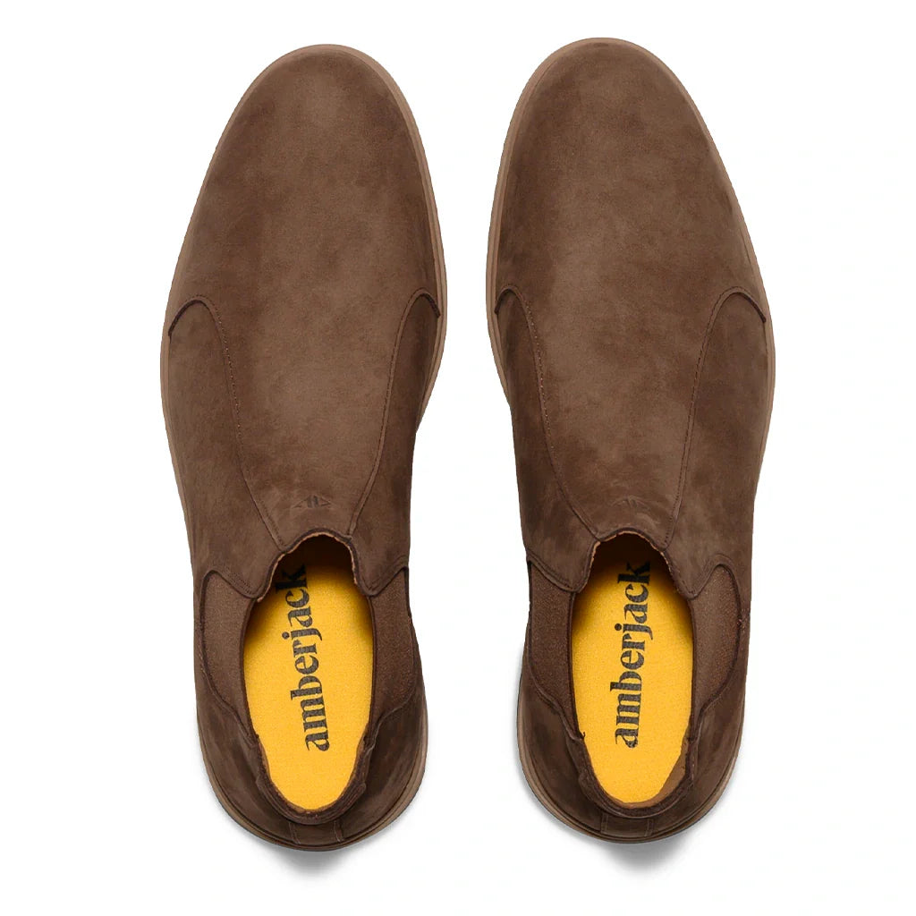 Brown suede shoes with yellow interior on a white background