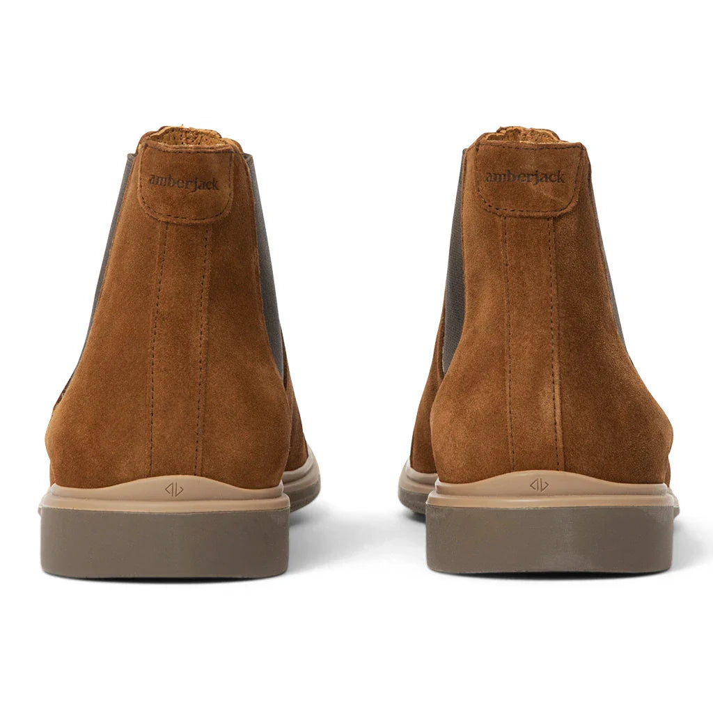 Pair of brown suede shoes with visible brand name on a white background