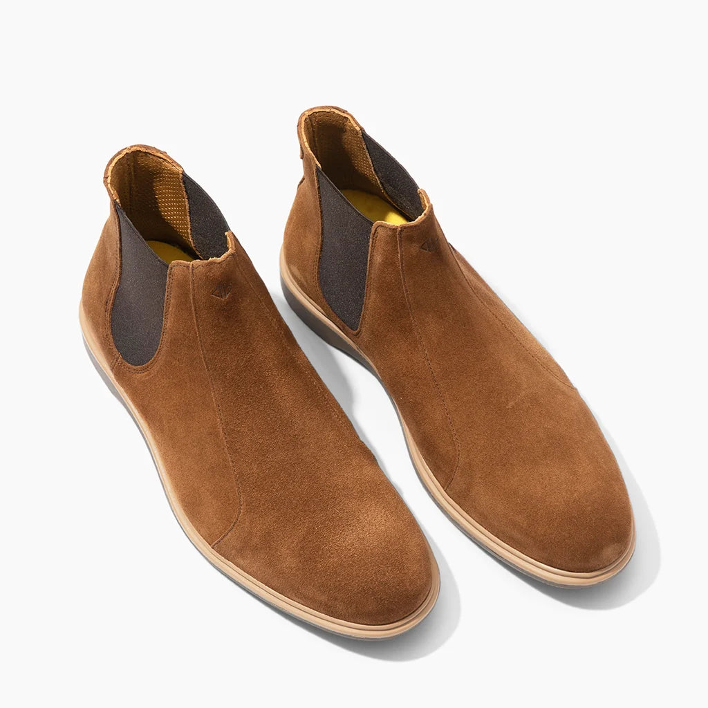 Pair of brown suede Chelsea boots on a white background