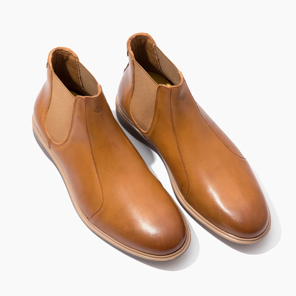 Pair of tan leather boots on a white background