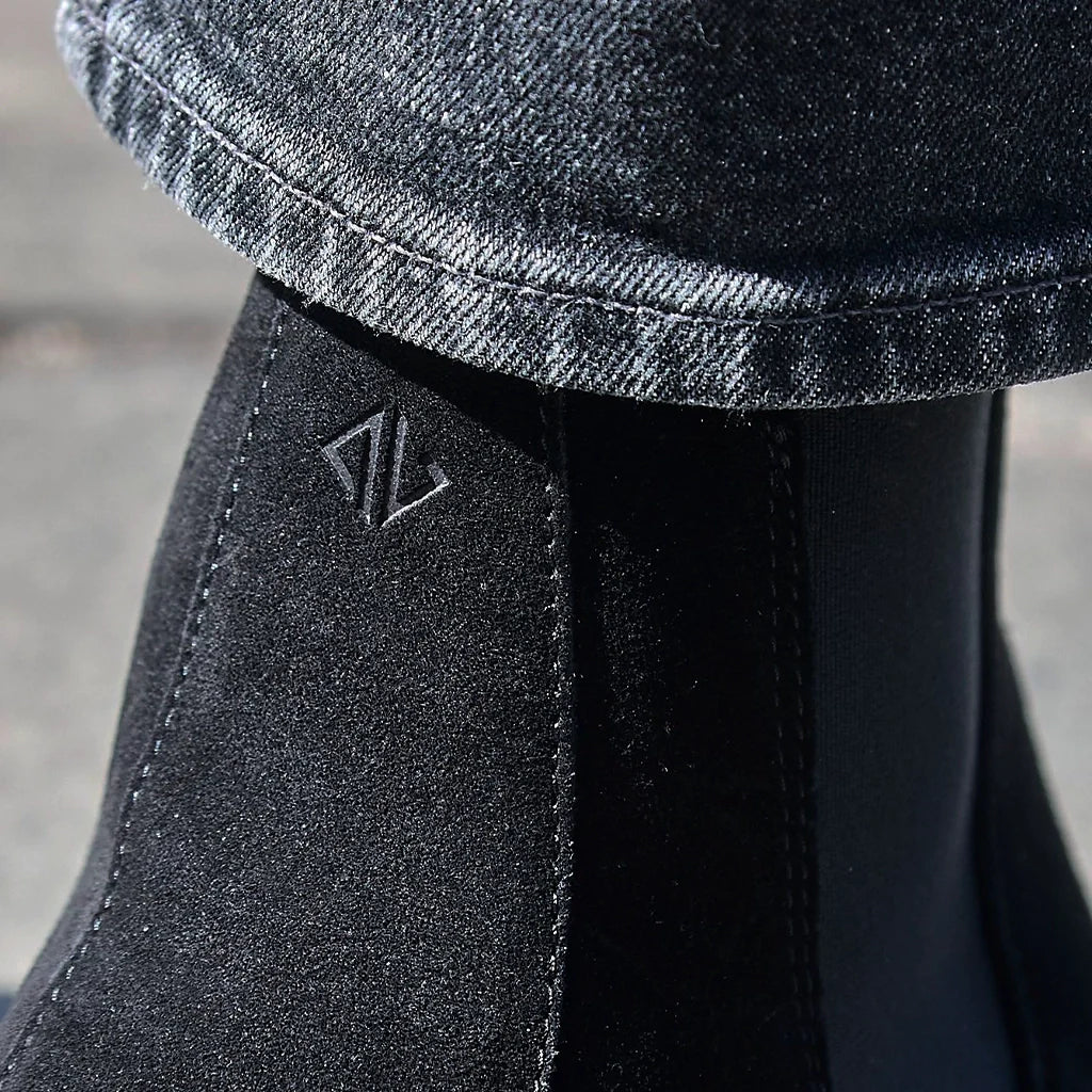Close-up of a black boot with a brand logo on a blurred background