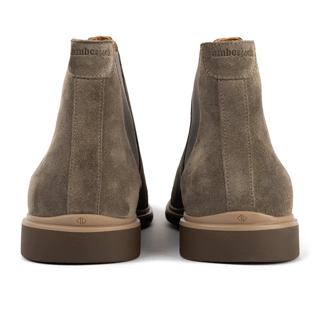 Pair of brown suede boots with brand logo on a white background