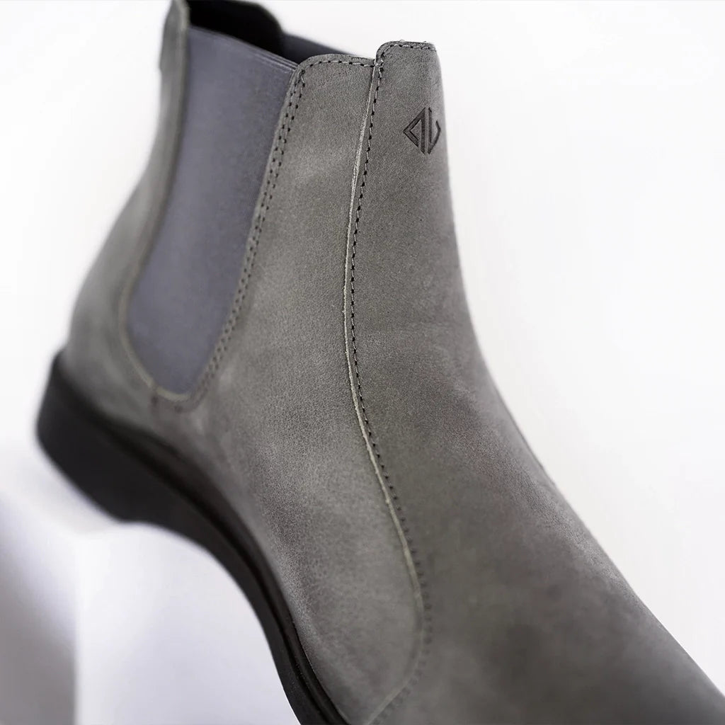 Gray suede shoe with a brand logo on a white background