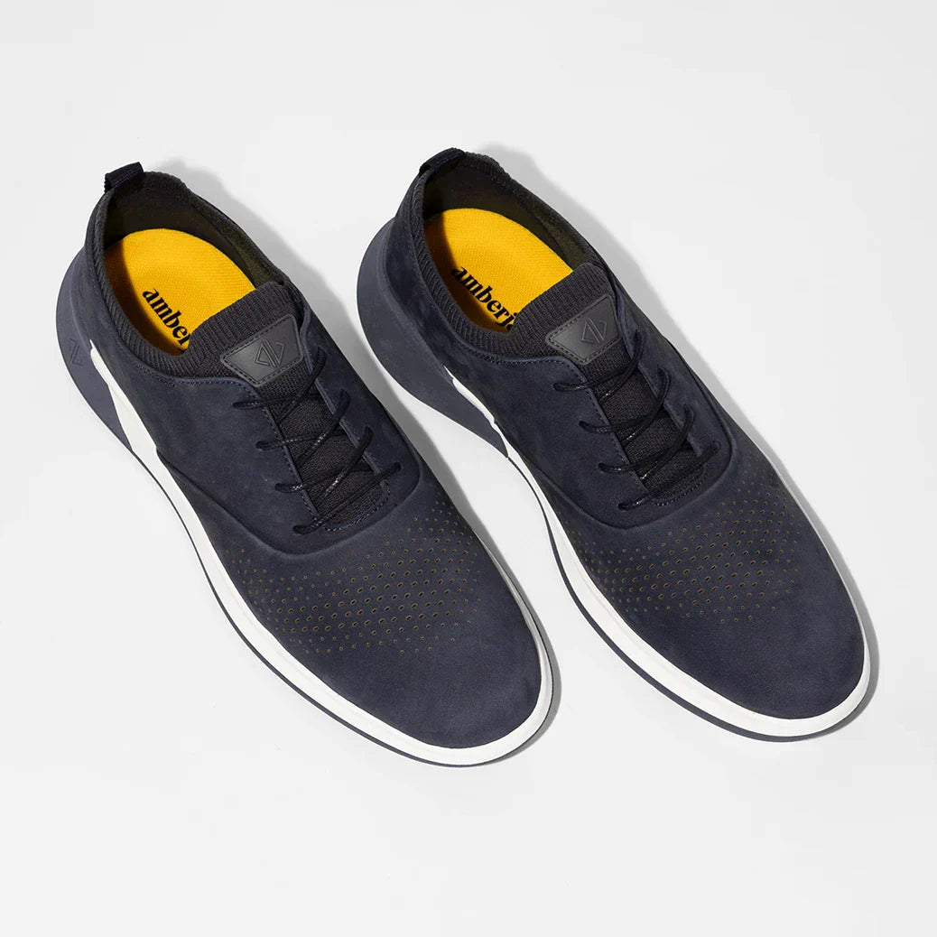 Pair of navy blue sneakers with yellow sole on a white background