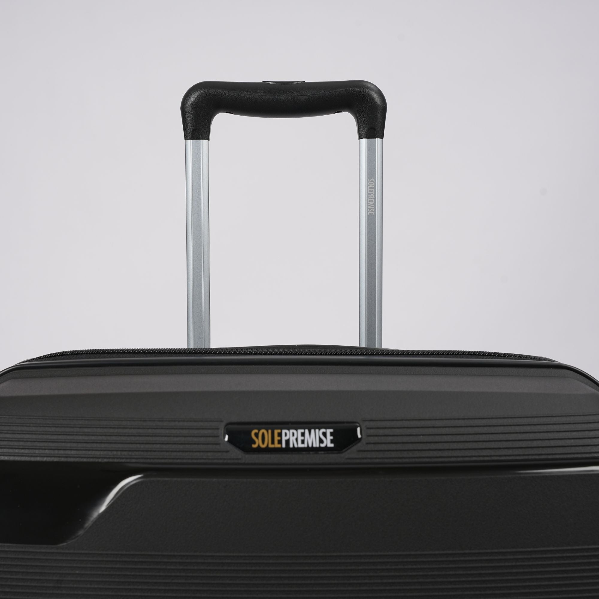 Black suitcase with 'SOLEPREMISE' label on a light gray background