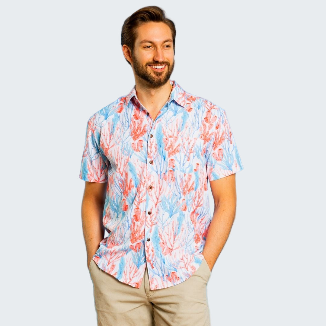Man wearing a colorful shirt against a blue sky with clouds