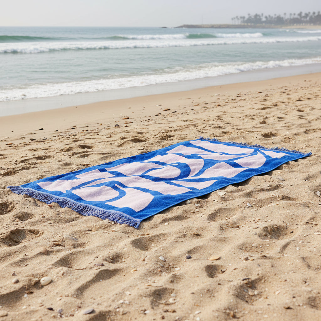Blue and white patterned towel with fringe on a white background