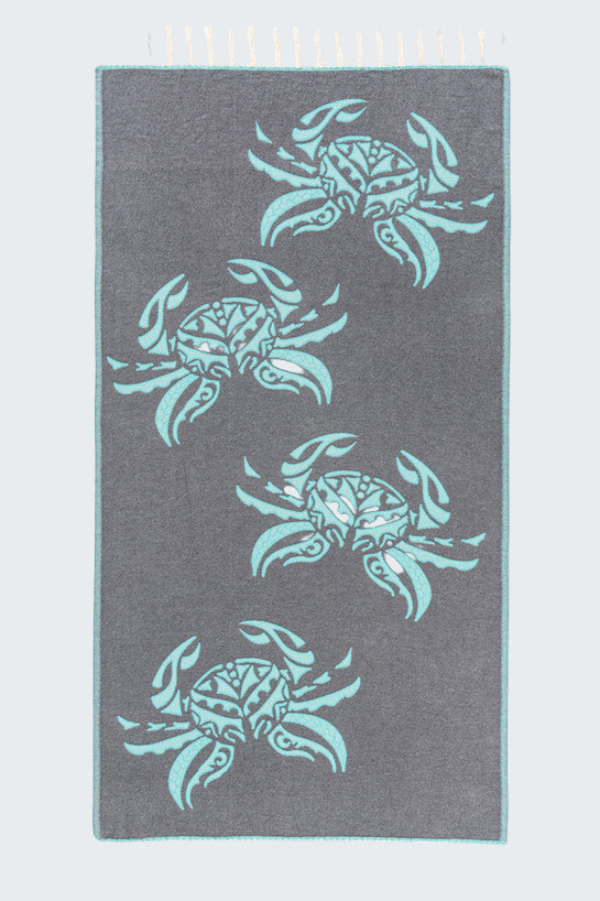 Gray towel with teal crab patterns on a white background