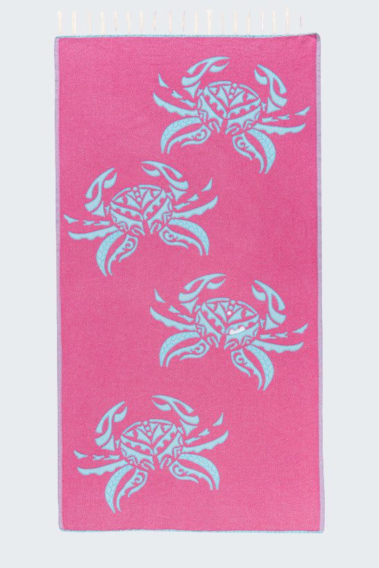 Pink towel with blue crab patterns on a white background
