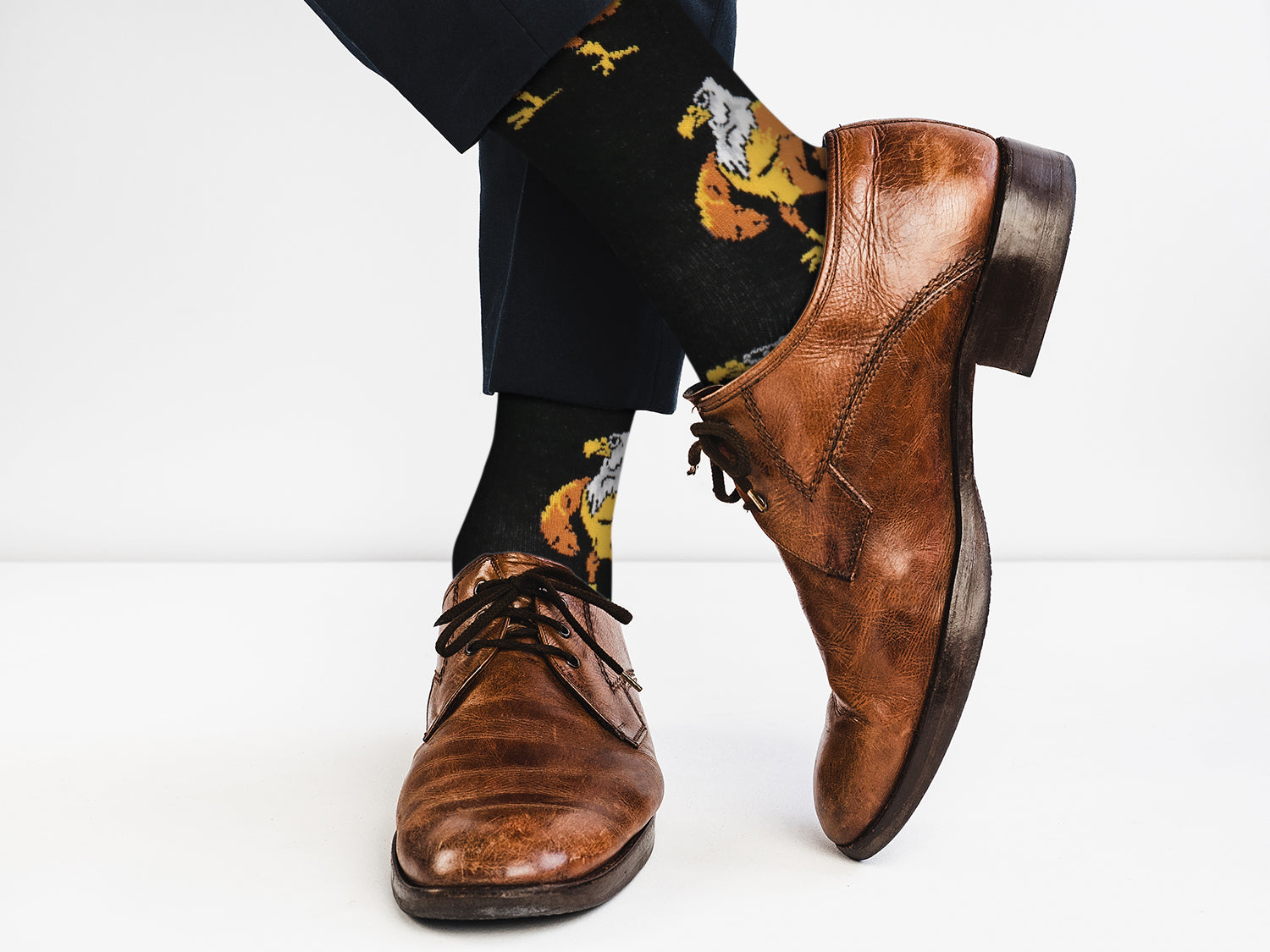 Brown dress shoes and patterned socks on a white background