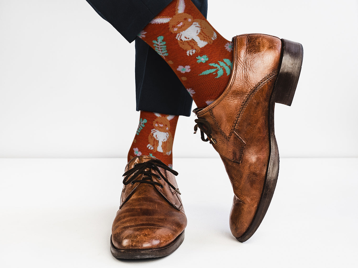 Brown leather shoes and patterned socks on a white background