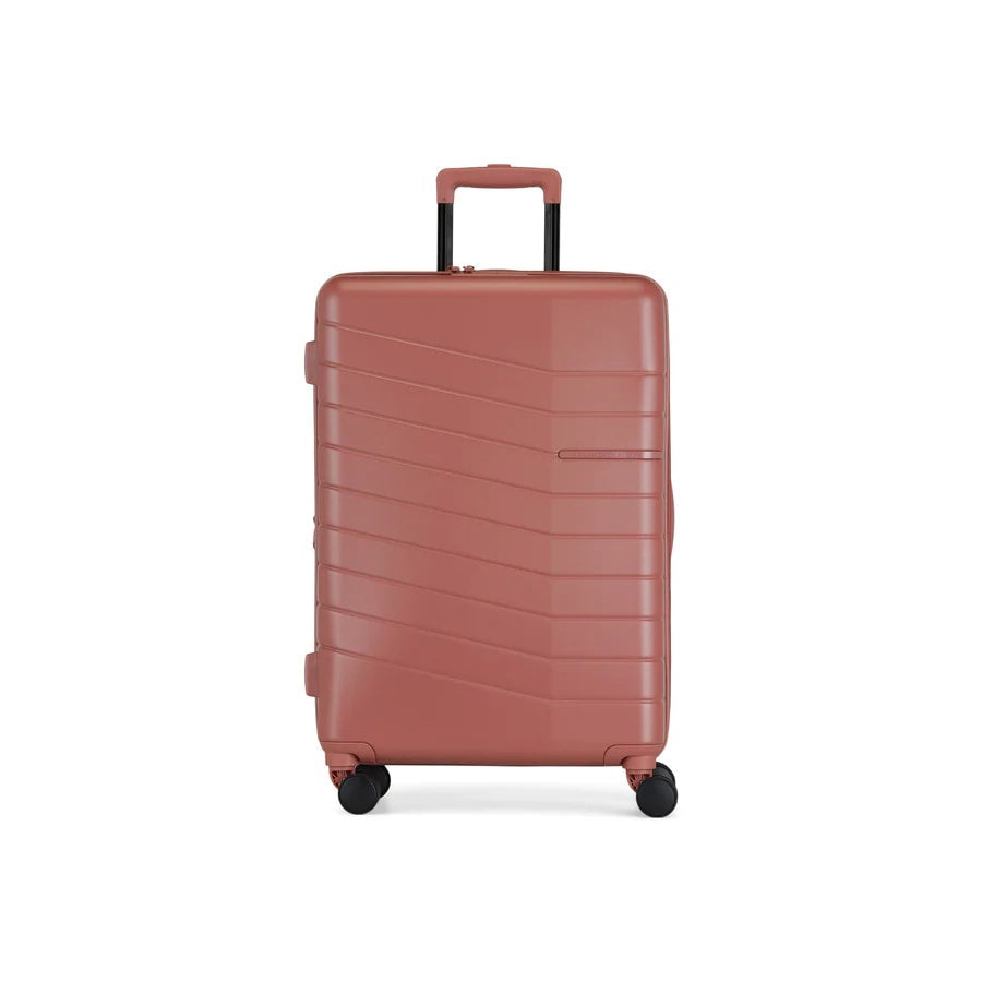 Pink suitcase with a textured surface on a white background