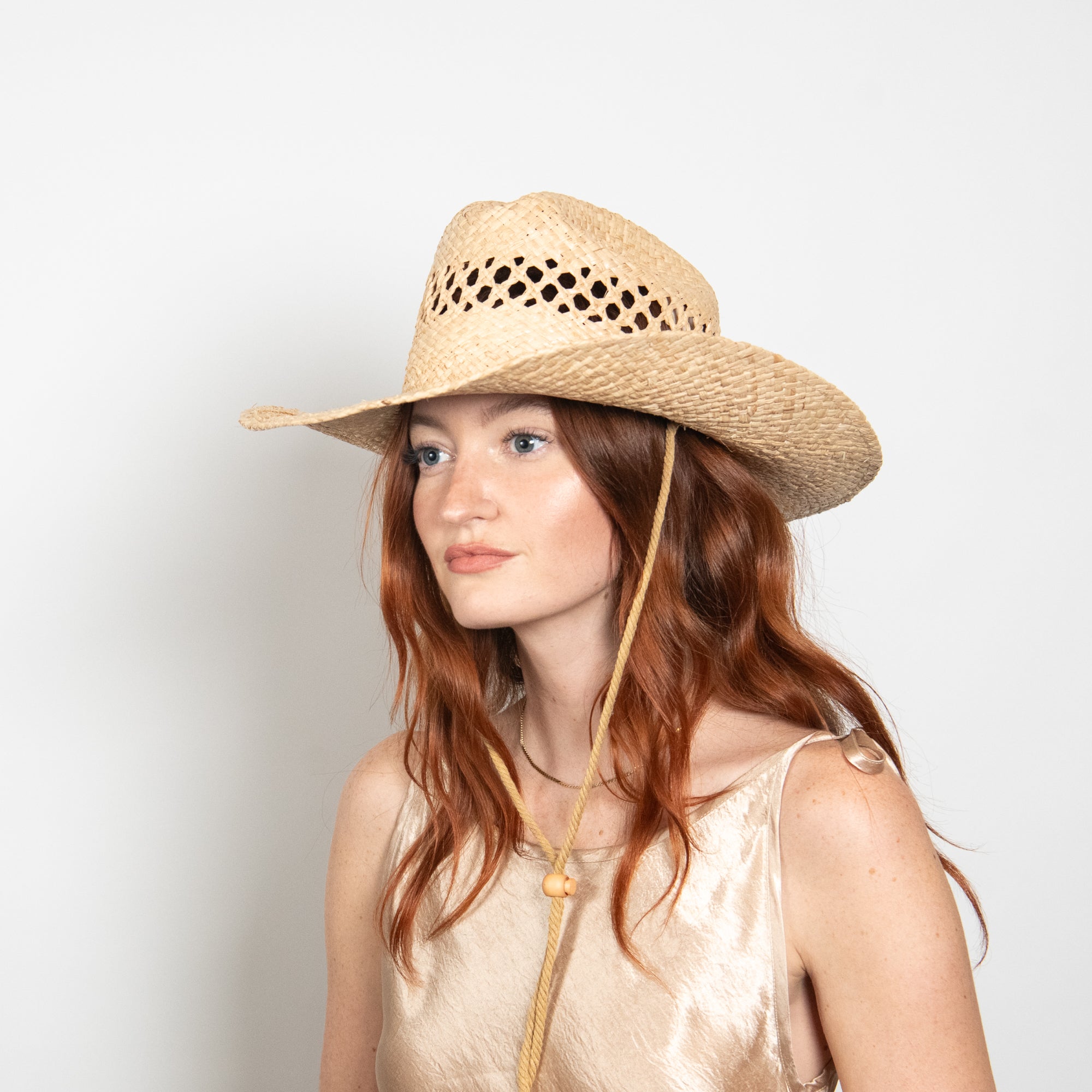 Woman wearing a straw hat with a plain background