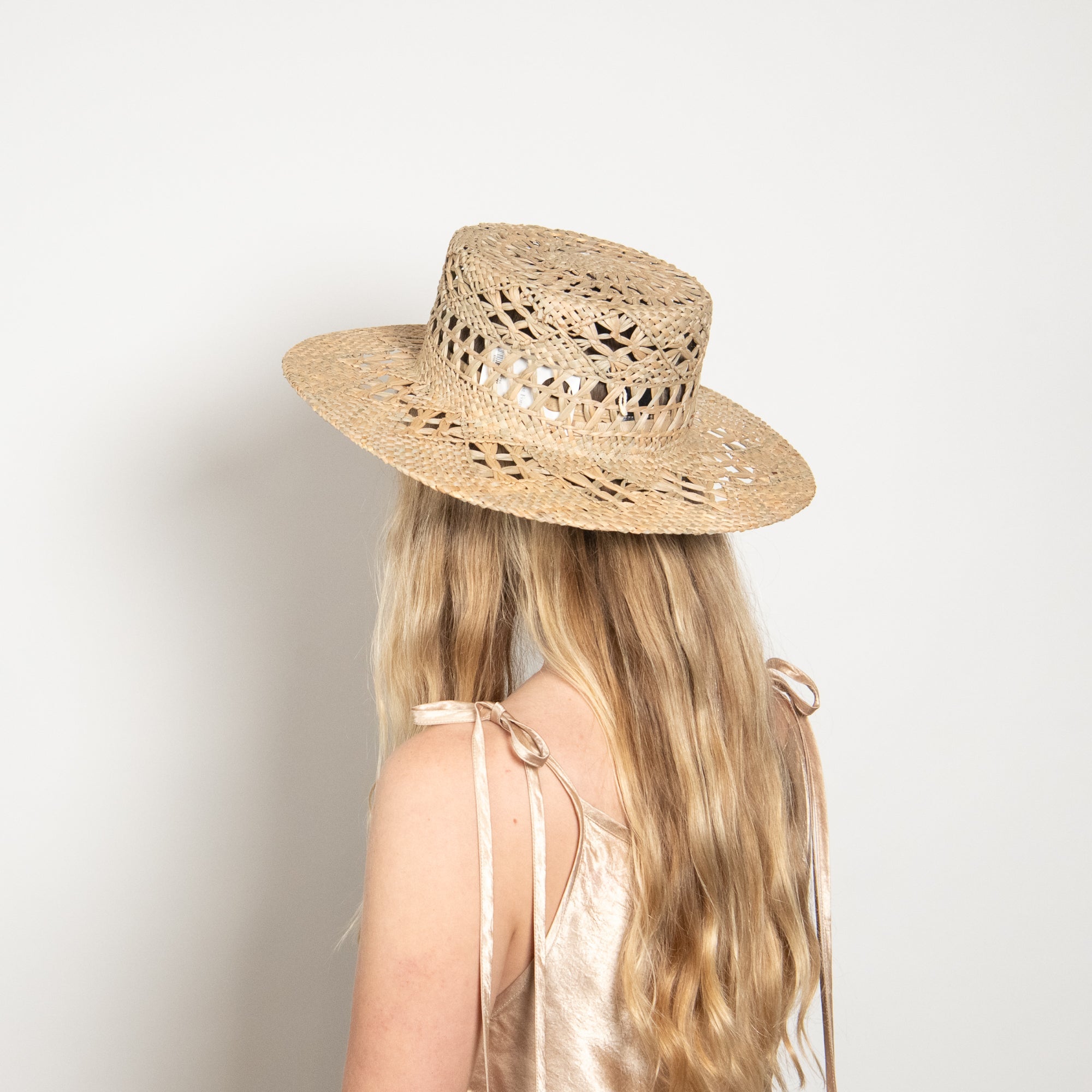 Person wearing a straw hat with a plain background