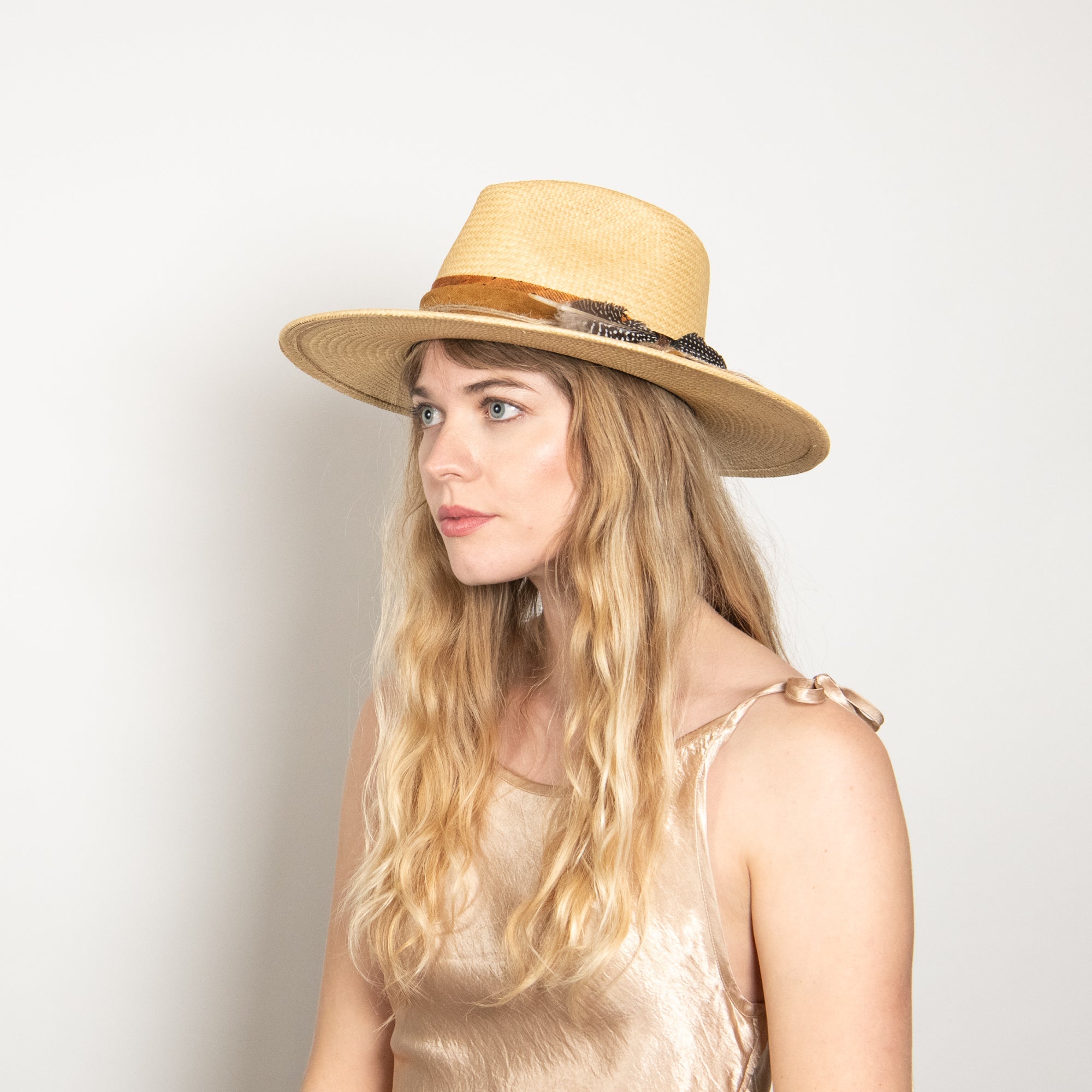 Woman wearing a straw hat against a plain background