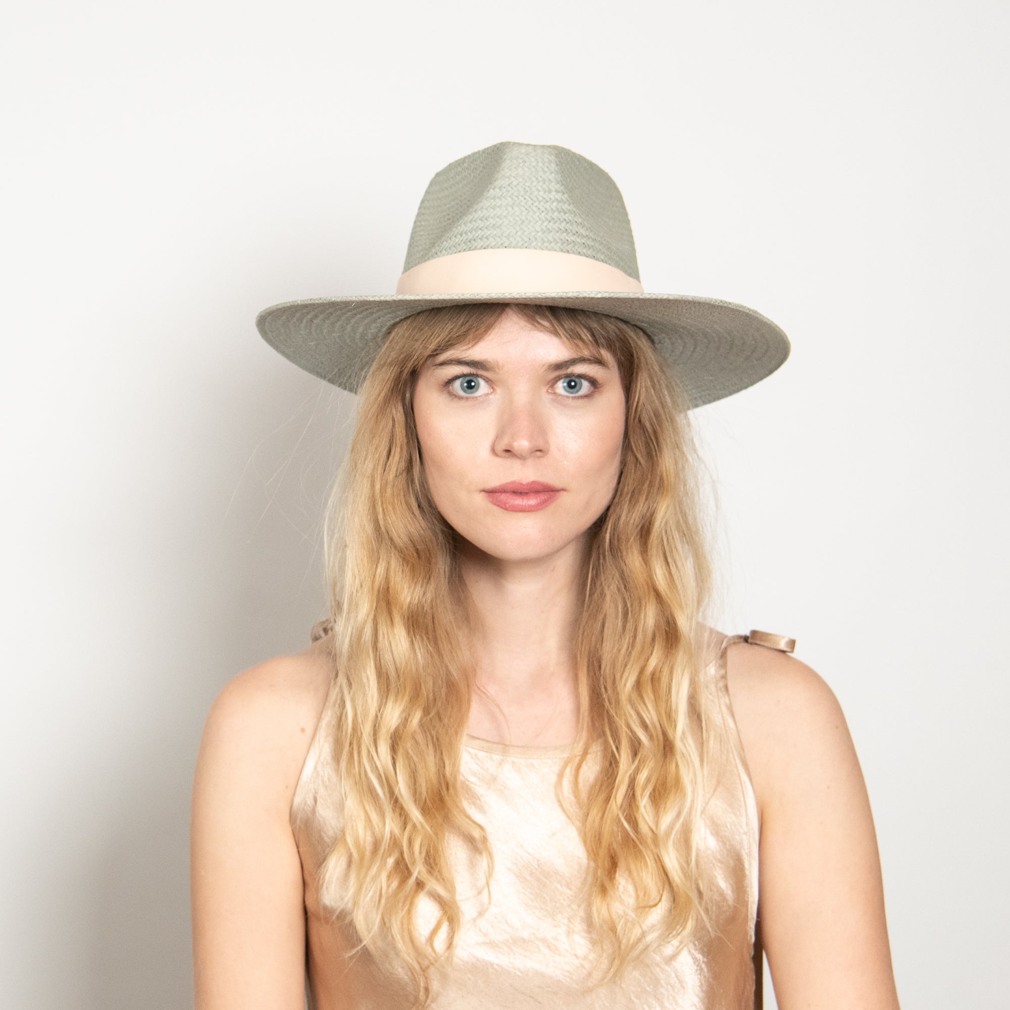 Woman wearing a green hat against a white background