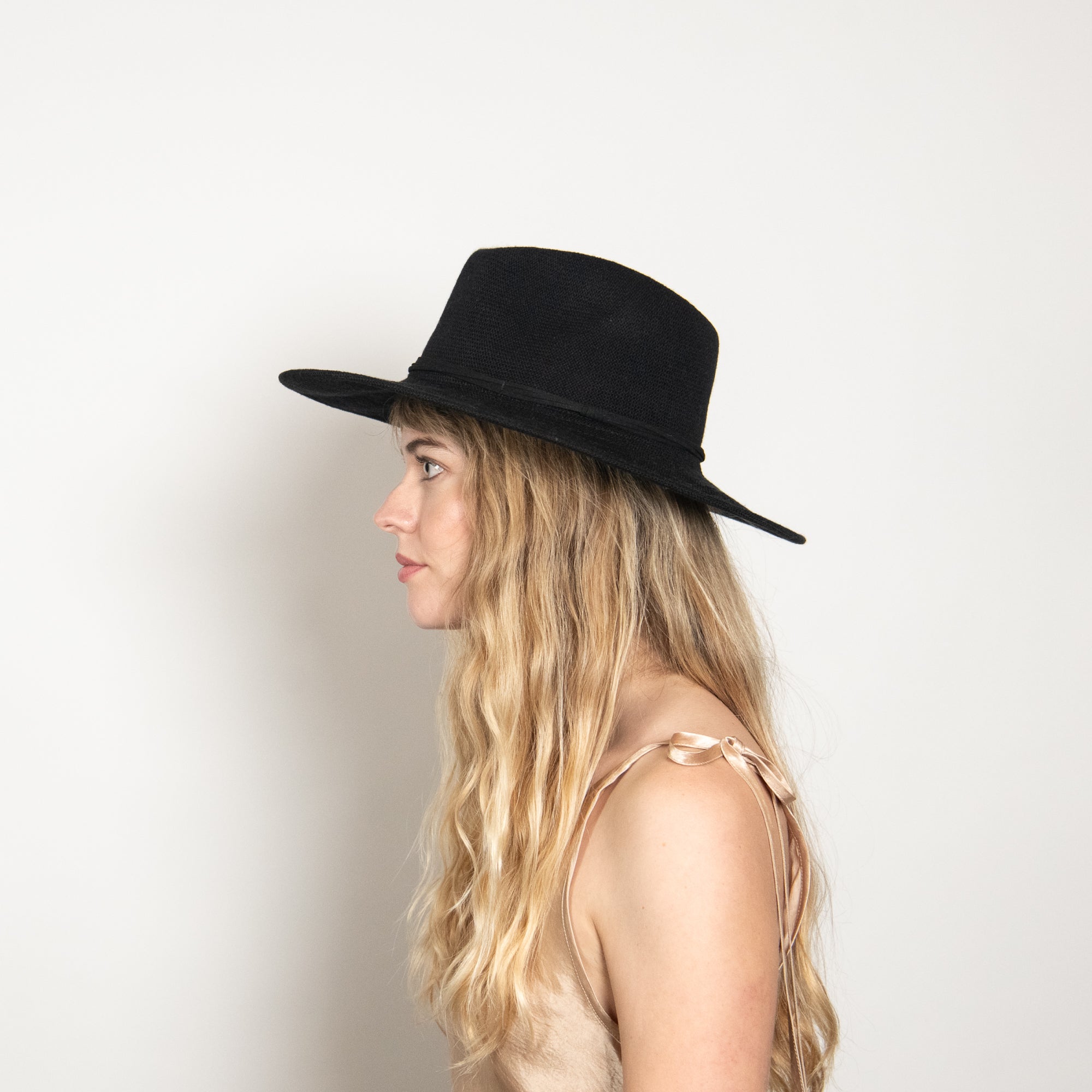 Woman wearing a black hat against a white background