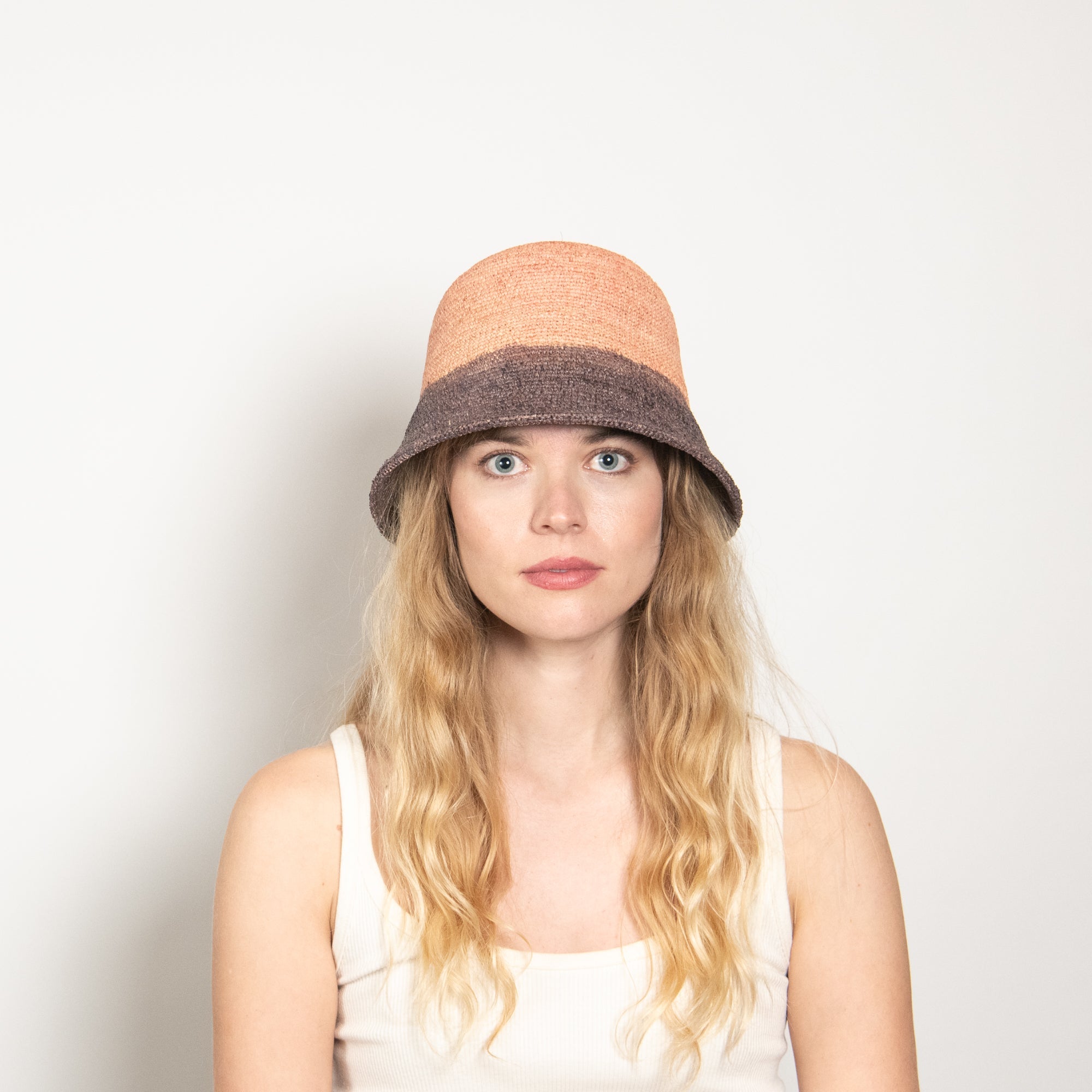 Woman wearing a two-toned bucket hat on a plain background