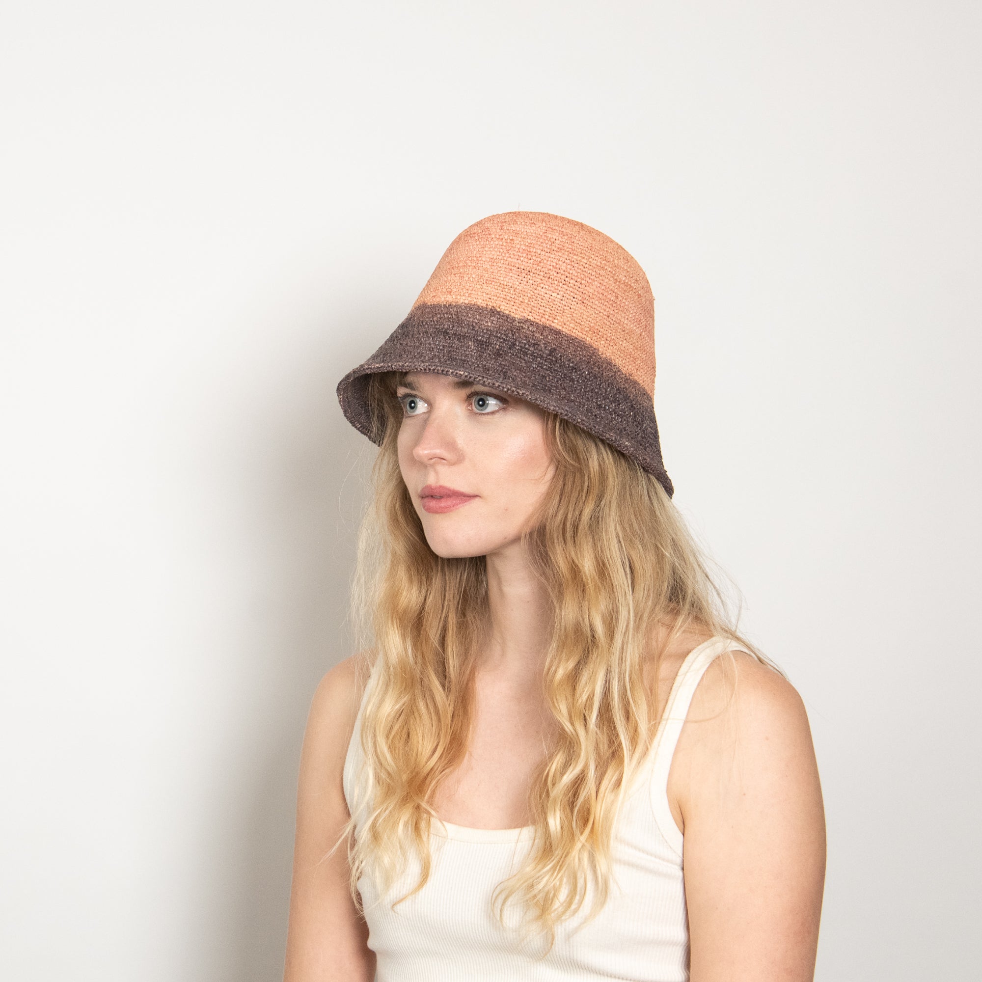 Woman wearing a two-tone hat with a plain background