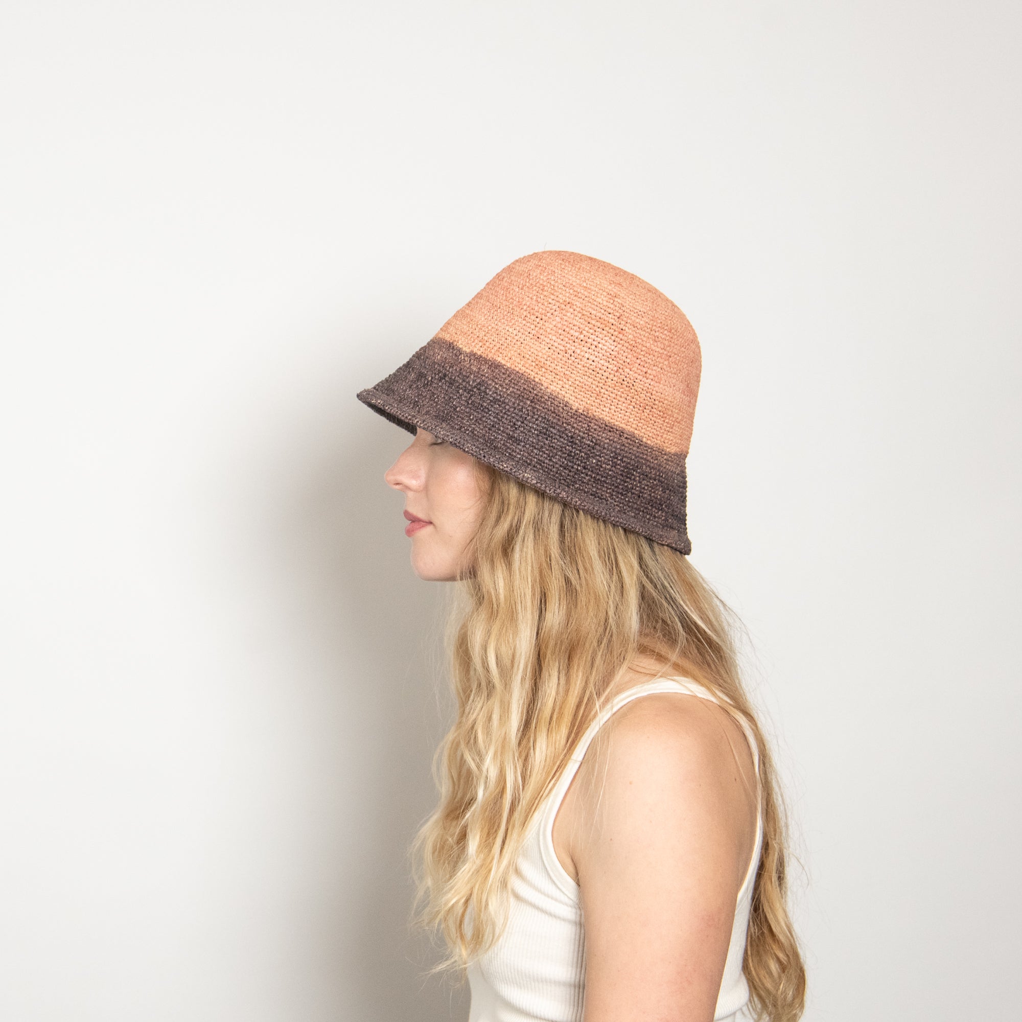 Woman wearing a two-tone hat with a plain background