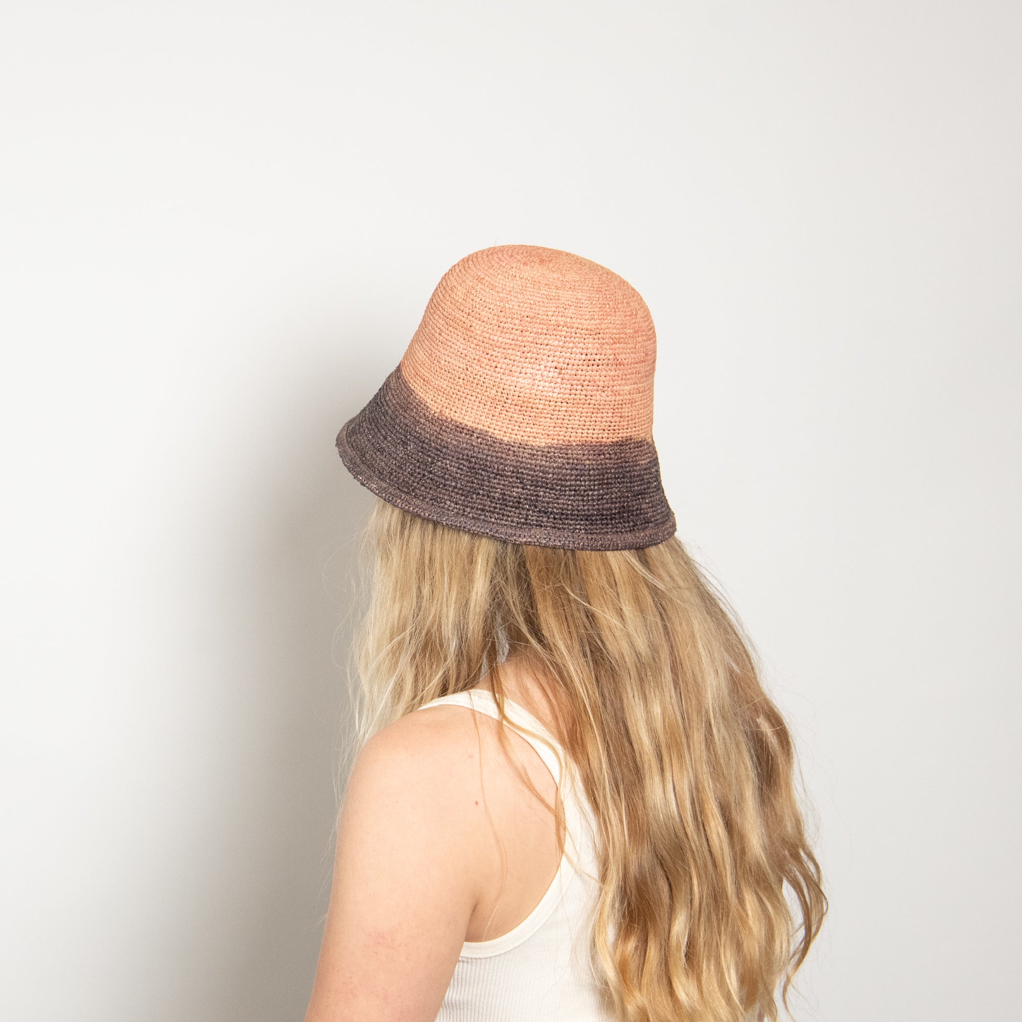 Person wearing a two-toned hat with a plain background