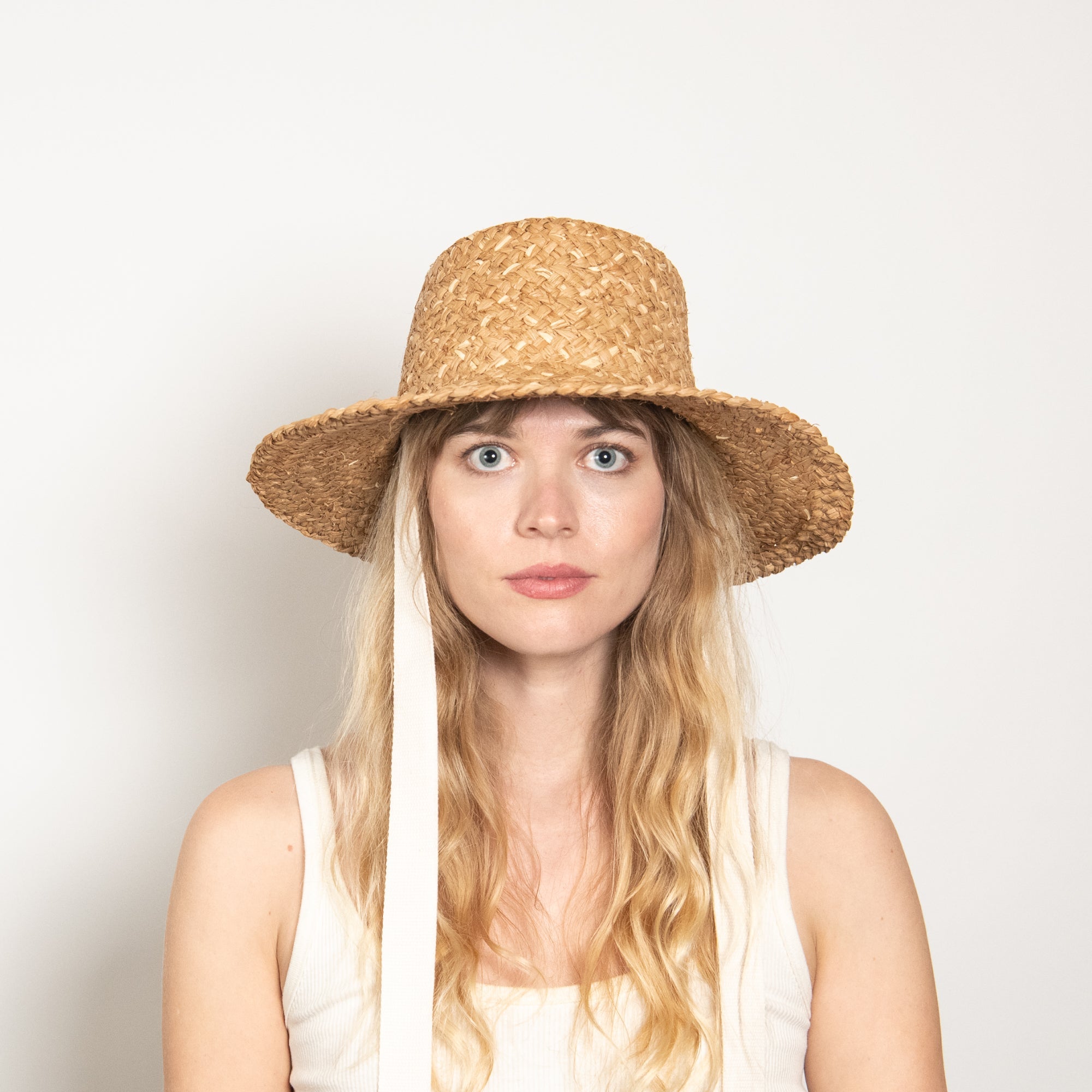 Woman wearing a straw hat with a white background