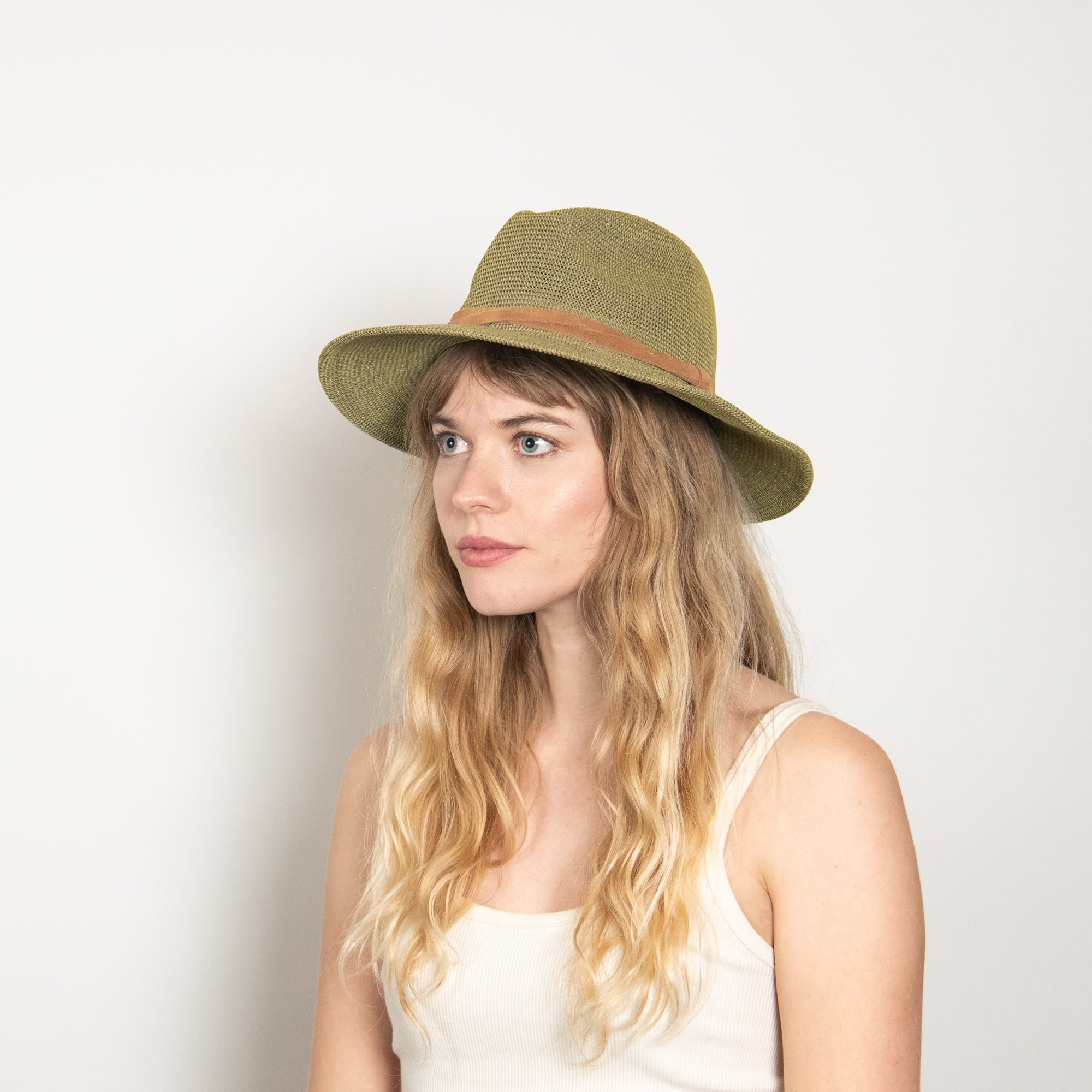 Woman wearing a green hat against a white background