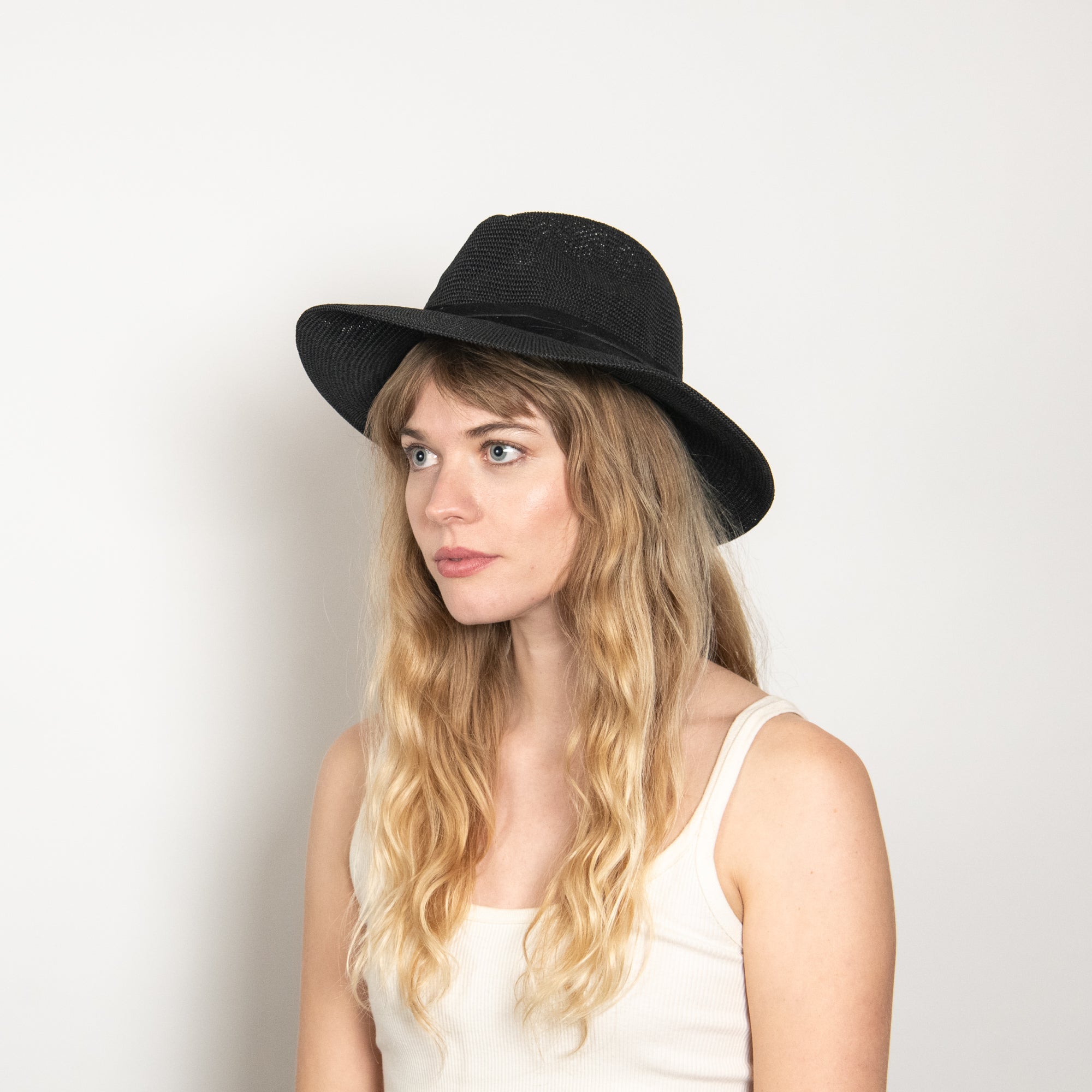 Woman wearing a black hat against a white background