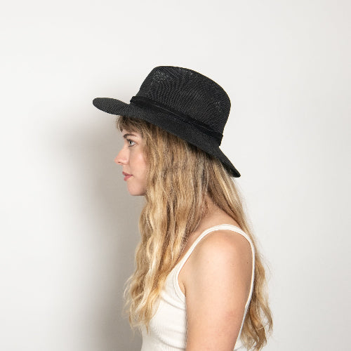 Woman wearing a black hat against a white background
