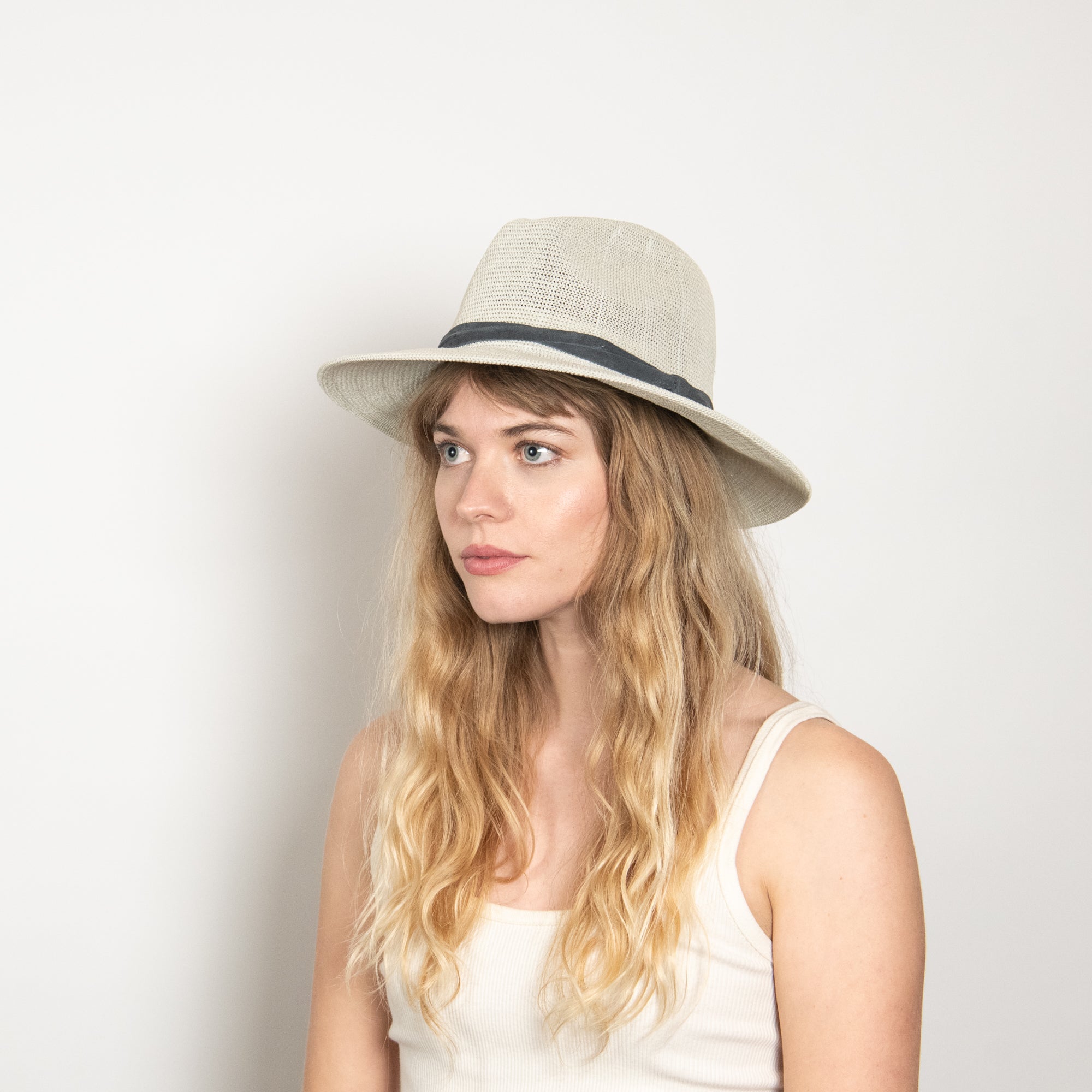 Woman wearing a straw hat against a plain background