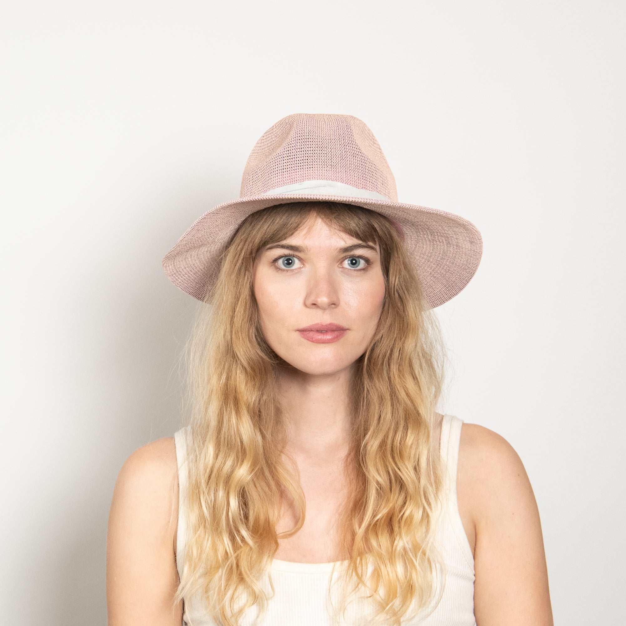 Woman wearing a pink hat against a plain background