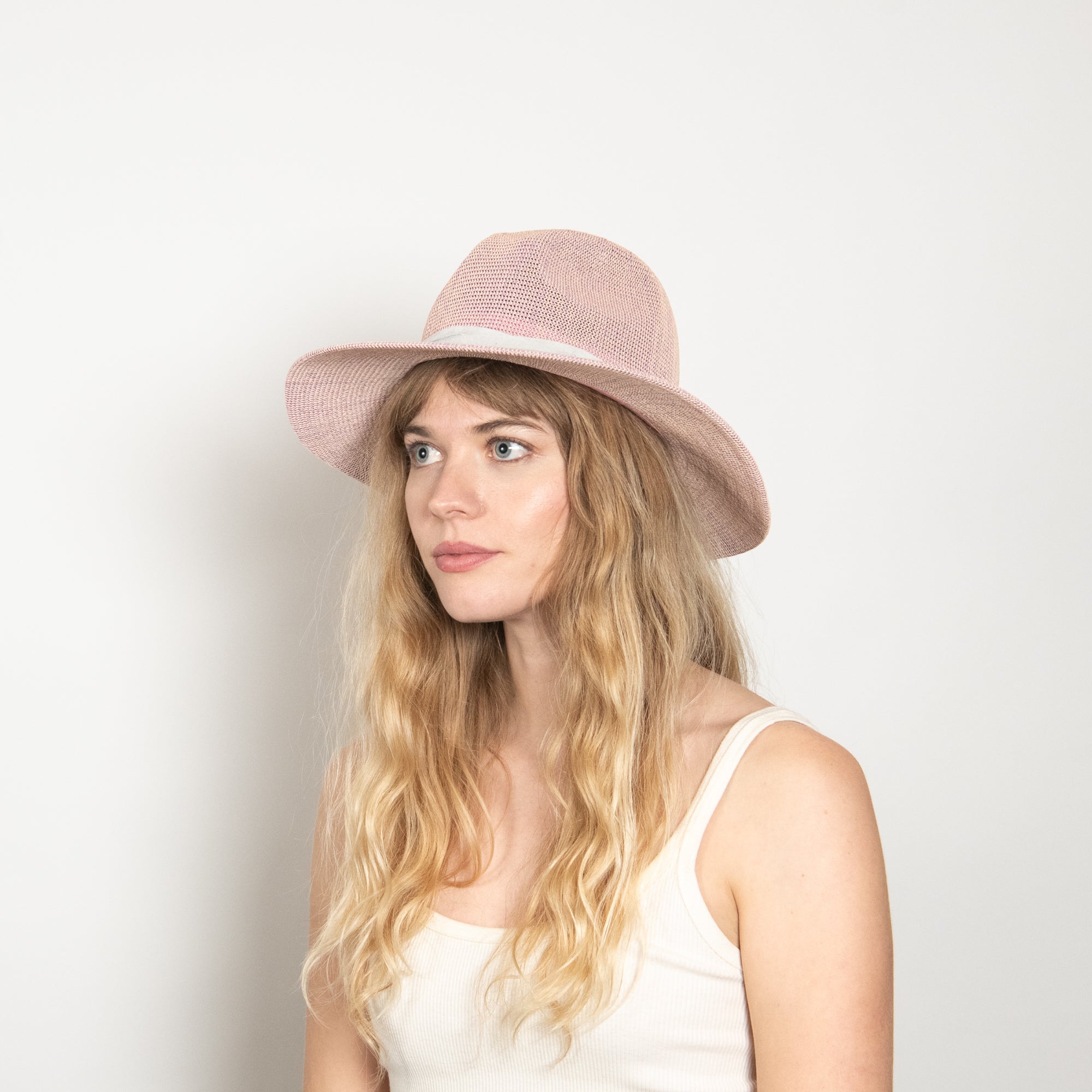 Woman wearing a pink hat against a plain background