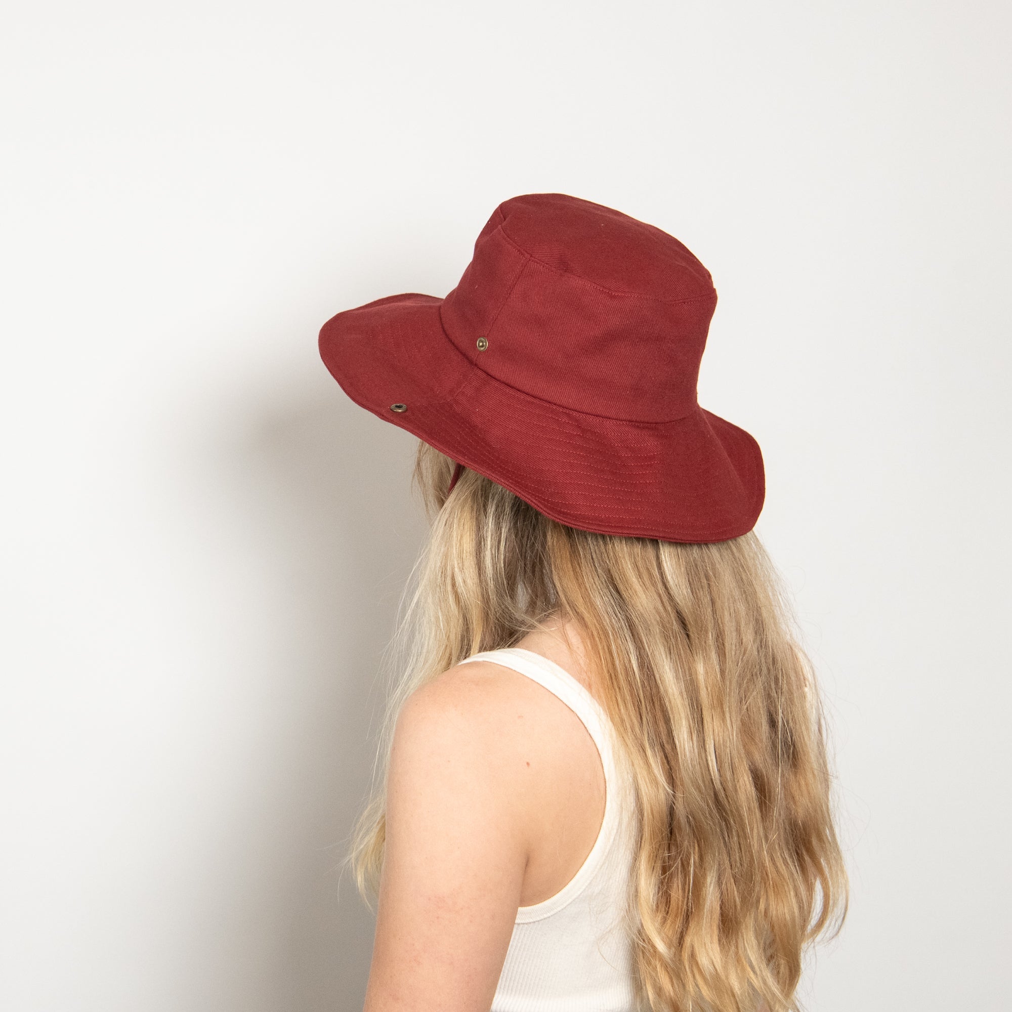 Person wearing a red bucket hat against a plain background