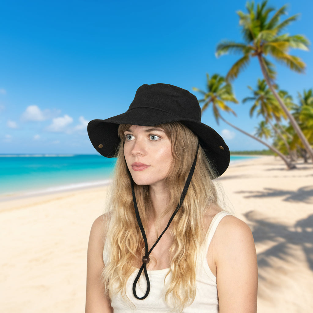 Woman wearing a black bucket hat with a chin strap on a light background