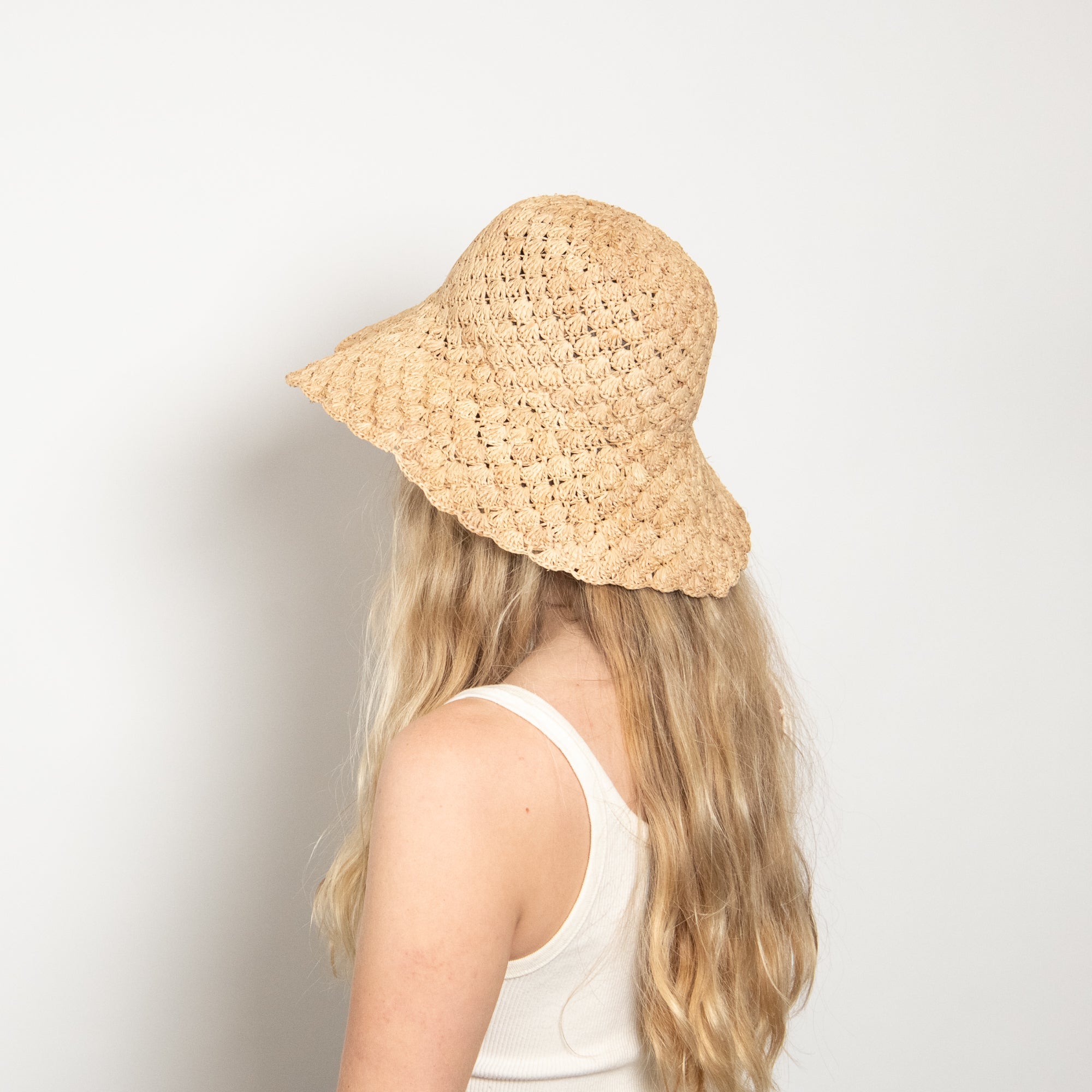 Person wearing a straw hat on a plain background