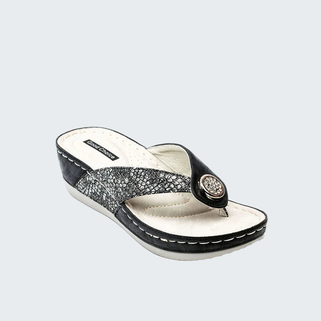 Black and white sandal with a decorative strap on a white background