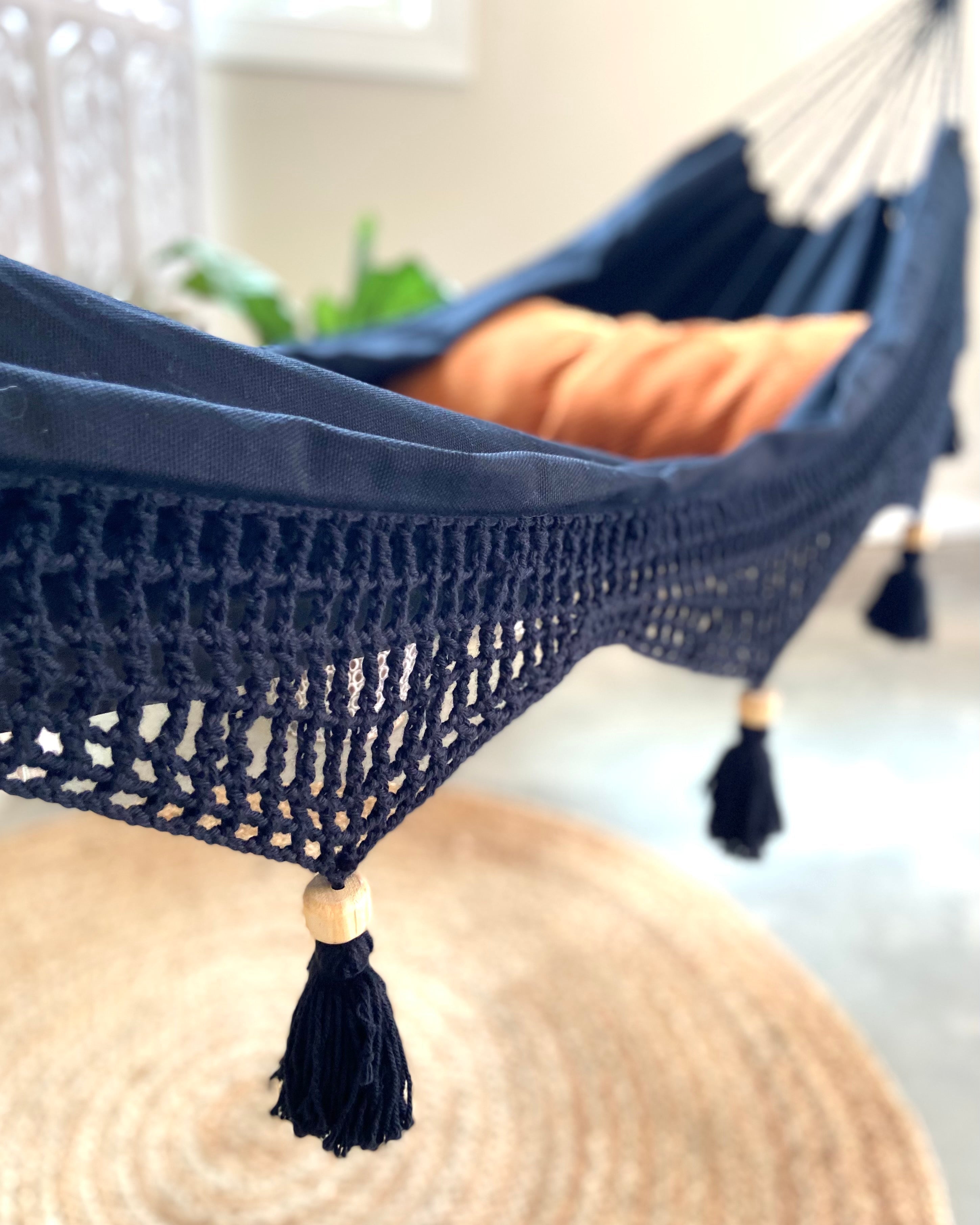 Navy blue hammock with tassels on a blurred background