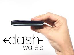 Hand holding a black wallet with 'dash-wallets' branding on a white background